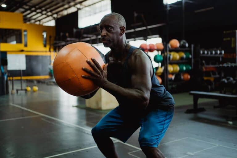 Man performing wall ball in gym