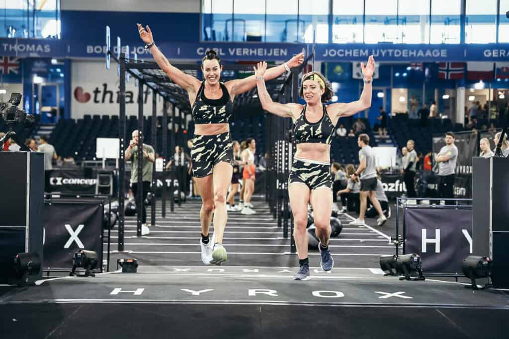Two women crossing the finish line of HYROX Doubles